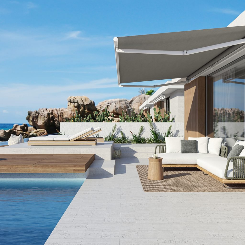 Modern grey Comunello MST-200 full-cassette awning deployed over a luxury poolside terrace.
