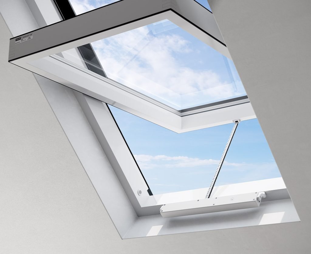 Interior view of a silver Comunello Mowin window actuator installed on a bottom-hung, inward-opening (vasistas) window frame.