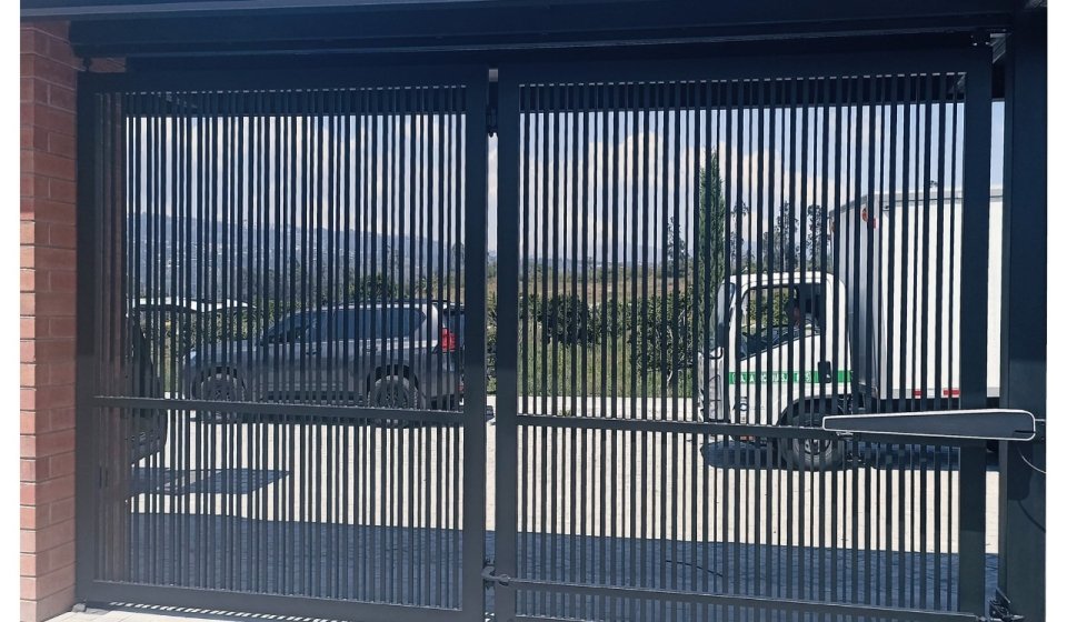 Front view of a black motorized sliding gate installed at a modern residence, showcasing Go Motion gate automation solutions.